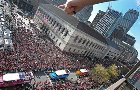A fan on the roof of a building on Boylston Street pointed during the parade near the Boston Public Library.
