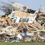 A man walked through a damaged home in Gifford, Ill., Sunday after thunderstorms and tornadoes battered the Midwest.