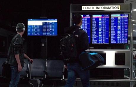 At Logan Airport, travelers checked the status of flights.

