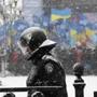 A policeman guarded the Ukrainian Parliament as supporters of President Viktor Yanukovych stood in the background.