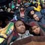 People sheltered under blankets during the memorial service for former South African president Nelson Mandela at Soweto soccer stadium in Johannesburg.