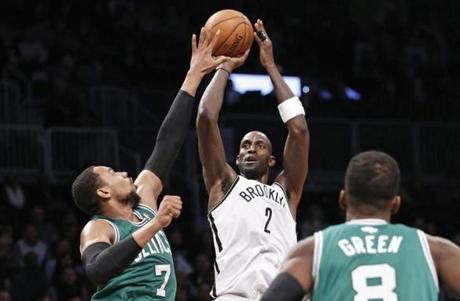 Kevin Garnett took a shot over Jared Sullinger as Jeff Green looked on.
