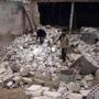 People walked on debris of damaged buildings at a site hit by what activists say was shelling by forces loyal to Syrian President Bashar Assad in  Damascus on Wednesday.