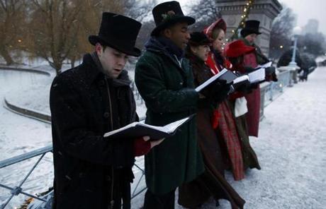 Carolers sang along the footbridge in the Public Garden in the snowfall.
