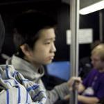 Johnny Huynh (foreground) and his brother, George, are seen on their bus ride to Boston Latin School.