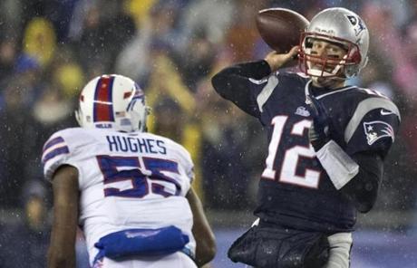 Tom Brady passed the ball under pressure from Jerry Hughes.
