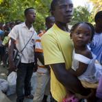 Louissien Pierra, 25, who was born in the Dominican Republic, held his 2-year-old daughter in November as they waited to board a bus to a Haitian town where they have family. Departures from the Dominican Republic to Haiti followed violence that erupted after a court ruling that could potentially revoke citizenship for residents of the Dominican Republic of Haitian descent.