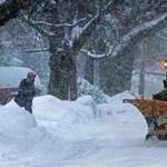A mail carrier went about his route as a plow passed by in Lawrence.