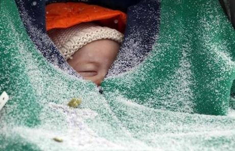 Two-month-old Jack Hsi took a nap while sheltered in his baby carriage in Boston.
