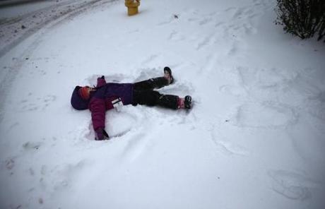 Resse Studebaker of Hingham didn't mind the weather as she made a snow angel while waiting at a bus stop.
