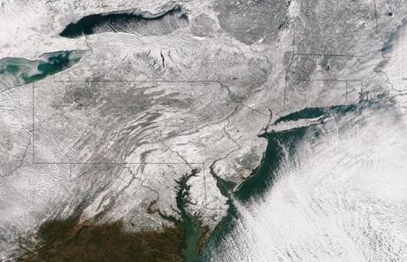 A satellite image shows the blanket of snow stretching through the Northeast.
