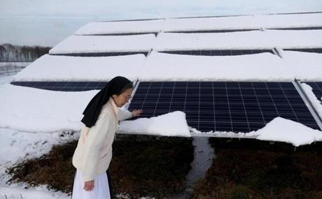 Sister Alice Chau checks on a solar panel in the power- (and revenue-) generating array set up by Mount Saint Mary’s Abbey in Franklin. 
