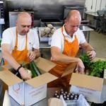 Anders Lindell (left) and Jan Leife, founders of Just Add Cooking, pack up the meal boxes, including spices, at the industrial Crop Circle Kitchen in Jamaica Plain. 
