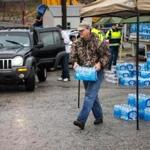 Members of a West Virginia volunteer fire department distributed bottled water to local residents on Saturday.