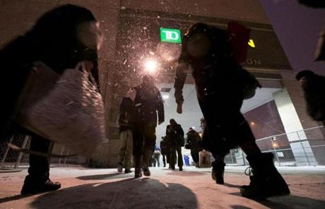 Commuters walked from the Green Line to North Station as snow fell Tuesday evening.
