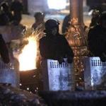 Riot police stood together facing a barricade of antigovernment protesters in Kiev.