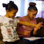 Sayra Alemany high-fived daughter Ly’eisha, 7, for a job well done on her homework. Alemany enrolled in a Crittenton Women’s Union program in 2012 and is now studying radiology at Bunker Hill Community College.