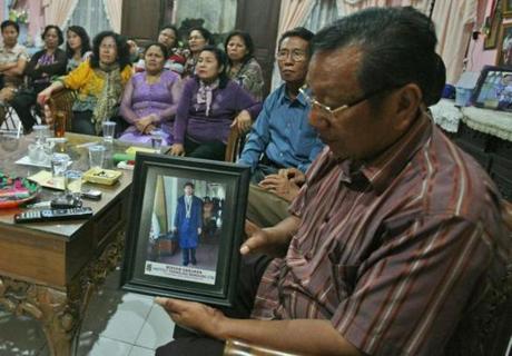 Chrisman Siregar (right) showed a portrait of his son, who is one of the passengers on the missing Malaysia Airlines plane.
