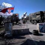 A Russian flag (L) floats alongside a Serbian flag (2nd L) and a Russian navy flag (C) as a military truck belonging to Russian forces passed a check point on the road from Simferopol to Sevastopol.  