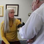 Nancy Nangeroni, who says she has suffered neck, shoulder, and back pain since a 2004 auto accident, brought her medical records with her in a visit to  Dr. Joey Rottman to get certified for medical marijuana.