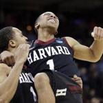 Harvard’s Siyani Chambers (right) leaps into the arms of teammate Brandyn Curry to celebrate the win. (AP Photo/Elaine Thompson)