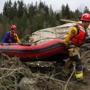 Rescue workers carried an inflatable boat to the flooded area in the debris field.