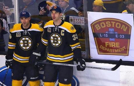 Johnny Boychuk (left) and Zdeno Chara wore hats with the Fire Department's insignia during pregame warm-ups.
