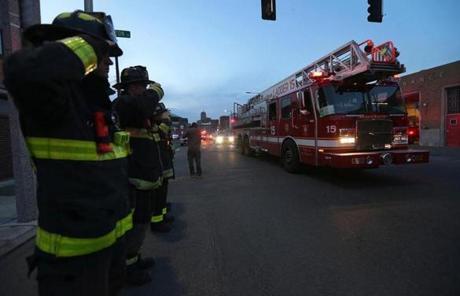 Firefighters stood at attention as a motorcade carrying one of the fallen firefighters drove by on Massachusetts Avenue.
