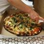 A pizza was prepared for a take out customer at Frank Pepe Pizzeria on Wooster Street in New Haven's Little Italy.