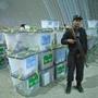 An Afghan police officer guarded ballots as election workers noted serial numbers on ballot boxes.