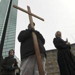 Robert Yearwood carried a wooden cross as the Rev. Rainey G. Dankel led dozens of parishioners around the Back Bay. They stopped at the Marathon bombing and Beacon Street fire sites.