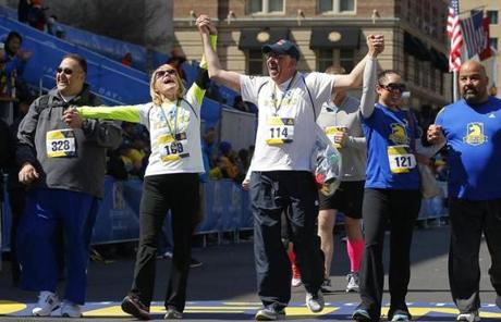 Beth (second from left) and Michael (center) Bourgault, bombing survivors, crossed the finish line during the Tribute Run.
