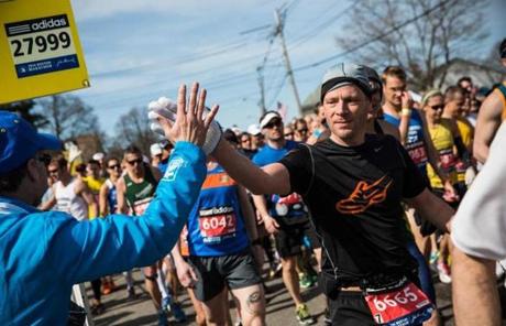 A runner gave a high five at the beginning of the Boston Marathon.
