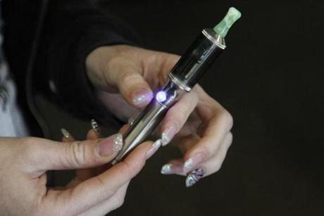 Store manager Jessica Tyron held her e-cigarette while waiting for a customer at Sweet Creek Vapors in East Ridge, Tenn.
