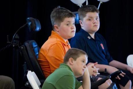 Jack Willis (orange shirt), Nolan Willis, (right), and Max LeClaire, who are afflicted with a muscle-wasting disease called Duchenne muscular dystrophy, attended the opening of Sarepta Therapeutics’ new headquarters in Cambridge on Monday.
