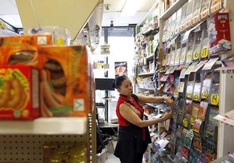 Teresa Nguyen gave a lottery ticket for a customer as she worked behind the counter at Tan-Thang Market on Broadway in Chelsea on Wednesday.
