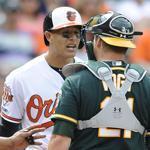 Home plate umpire Adrian Johnson separated Baltimore Orioles' Manny Machado, left, and Oakland Athletics catcher Stephen Vogt after Machado threw his bat into the infield.  