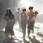 A woman and youths, one carrying a wounded baby, fled the site of a bomb attack in the city of Aleppo on Thursday.