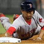Mookie Betts dives back to first on a pickoff try after he walked in the sixth. He scored his first run in the inning.