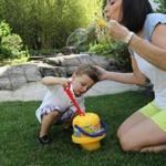 Kyle Donovan blows bubbles in her backyard with her 2-year-old son Matthew. She says she is often conflicted about wanting her son to have a sibling.