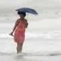A lifeguard spoke with beachgoers in Nags Head, N.C., on Thursday. Hurricane Arthur is forecast to pass by Hatteras Island on Friday morning. The island is under mandatory evacuation orders.