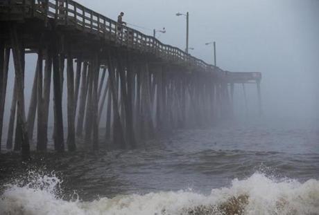 A man fished from the Nags Head Pier in North Carolina as fog and heavy surf rolled in ahead of Hurricane Arthur.
