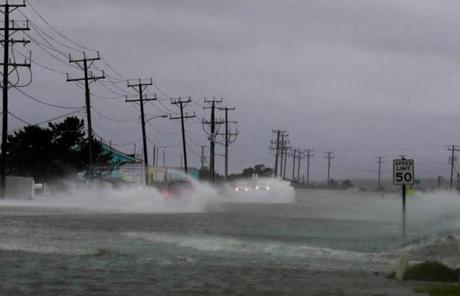 Vehicles navigated a flooded state highway through Nags Head, N.C., early Friday.
