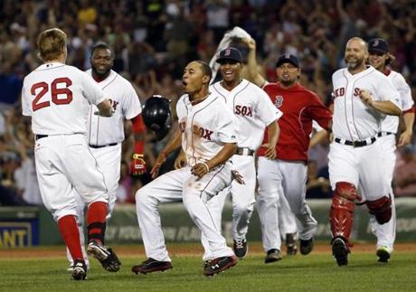 Boston Red Sox's Brock Holt (26) celebrates with teammates including Mookie Betts, front center, after he hit an RBI single to win a baseball game against the Chicago White Sox 5-4 at Fenway Park in Boston, Wednesday, July 9, 2014. 
