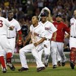 Boston Red Sox's Brock Holt (26) celebrates with teammates including Mookie Betts, front center, after he hit an RBI single to win a baseball game against the Chicago White Sox 5-4 at Fenway Park in Boston, Wednesday, July 9, 2014. 