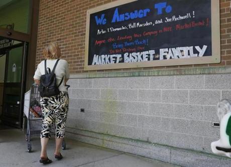 A shopper stops to read a sign in support of ousted Market Basket president Arthur T. Demoulas
