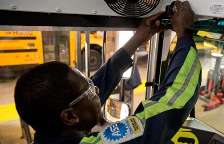 Andrew Prince, a technician with the Boston School Department, installed a video camera in one of the school buses that will be used this fall.
