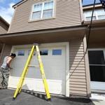 Jim and Teresa Anapol left a four-bedroom house in Stow for the convenience of a condo, here getting a new garage door.
