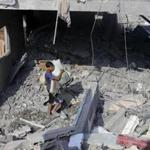 A Palestinian youth carried his belongings from a house in Rafah in the southern Gaza Strip that witnesses said had been hit by an Israeli airstrike.
