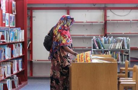 Fosiya Ismail browsed through books at the Boston Public Library?s Dudley Branch with empty stacks nearby.
